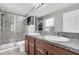Bright bathroom featuring a double sink vanity, granite countertop, and a glass-enclosed shower at 17316 Cruiser Bnd, Land O Lakes, FL 34638