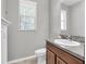 Bathroom with a granite-topped vanity, modern sink, neutral walls, and toilet under a sunlit window at 17316 Cruiser Bnd, Land O Lakes, FL 34638