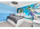 Bright bedroom features a built-in bed frame with storage and a vibrant tropical mural on the wall at 17316 Cruiser Bnd, Land O Lakes, FL 34638