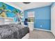 Comfortable bedroom with a palm tree mural, blue walls, and functional furniture at 17316 Cruiser Bnd, Land O Lakes, FL 34638