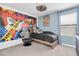 Vibrant bedroom with a colorful Lego mural wall, ceiling fan, and cozy furnishings at 17316 Cruiser Bnd, Land O Lakes, FL 34638