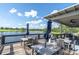 Outdoor patio with tables, chairs and umbrellas overlooking a tranquil lake view at the clubhouse at 17316 Cruiser Bnd, Land O Lakes, FL 34638