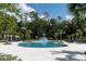 Large community pool with a splash pad, lounge chairs, and lush greenery, perfect for relaxation at 17316 Cruiser Bnd, Land O Lakes, FL 34638