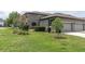 Landscaped front yard with lush green grass, mature trees, and well-maintained bushes adds curb appeal at 17316 Cruiser Bnd, Land O Lakes, FL 34638