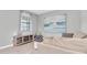 Cozy living room featuring a large window, modern entertainment center, and comfortable neutral-toned sofa at 17316 Cruiser Bnd, Land O Lakes, FL 34638