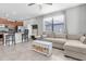 Open-concept living area with a modern kitchen island, comfortable seating, tile floors, and plenty of natural light at 17316 Cruiser Bnd, Land O Lakes, FL 34638