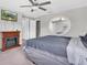 Bedroom with a ceiling fan, TV, electric fireplace and large mirror at 17316 Cruiser Bnd, Land O Lakes, FL 34638