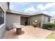 View of the brick patio with a barrel table, bench, and covered area at 17316 Cruiser Bnd, Land O Lakes, FL 34638