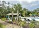 Community pool with lounge seating and shade, surrounded by palm trees and landscaping at 17316 Cruiser Bnd, Land O Lakes, FL 34638