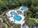 Aerial view of community pool featuring multiple swimming areas, slides, and lounge chairs at 17316 Cruiser Bnd, Land O Lakes, FL 34638