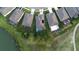Aerial view of home with a screened-in pool near mature trees and a serene pond at 17679 Garsalaso Cir, Brooksville, FL 34604