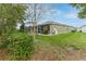 Spacious backyard featuring a screened-in pool area, healthy green lawn, and mature shrubbery at 17679 Garsalaso Cir, Brooksville, FL 34604