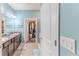 Bright bathroom featuring double sinks, granite countertop, and a walk-in closet for storage at 17679 Garsalaso Cir, Brooksville, FL 34604