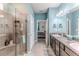 Well-lit bathroom with a glass door shower, dual sinks, and access to the Primary bedroom at 17679 Garsalaso Cir, Brooksville, FL 34604