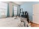 Bright bedroom with two windows and blue accent wall, furnished with a bed, dresser, and mounted TV at 17679 Garsalaso Cir, Brooksville, FL 34604
