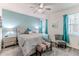 Relaxing bedroom with a ceiling fan, natural light, and a cozy seating area at 17679 Garsalaso Cir, Brooksville, FL 34604