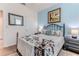 Comfortable bedroom with blue accent wall, metal-framed bed, and wood flooring, with a soft area rug at 17679 Garsalaso Cir, Brooksville, FL 34604