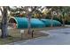 Outdoor golf cart storage facility with green tarp and fenced area, providing secure equipment storage at 17679 Garsalaso Cir, Brooksville, FL 34604