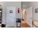 Neutral hallway featuring wood-look tile, a white door, a red wall clock, and an open doorway to other rooms at 17679 Garsalaso Cir, Brooksville, FL 34604