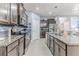 Modern kitchen with stainless steel appliances, granite countertops, and custom dark wood cabinetry at 17679 Garsalaso Cir, Brooksville, FL 34604