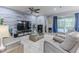 Inviting living room featuring comfortable gray seating, a modern accent wall, and a view of the screened pool area at 17679 Garsalaso Cir, Brooksville, FL 34604