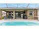 Backyard view with covered patio, screened pool with view of the house and its outdoor spaces at 17679 Garsalaso Cir, Brooksville, FL 34604