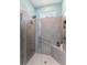 Modern shower with gray tiling, glass door, built-in bench and convenient grab bar for added safety at 17679 Garsalaso Cir, Brooksville, FL 34604