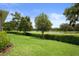 Lush backyard featuring a well-maintained lawn and golf course views, perfect for outdoor relaxation at 17727 Garsalaso Cir, Brooksville, FL 34604