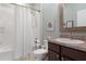 Bright bathroom with a white shower curtain, toilet, and dark vanity, offering a functional and clean design at 17727 Garsalaso Cir, Brooksville, FL 34604