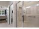 Bright bathroom featuring tiled walk-in shower with a seat and grab bars, with bedroom and toilet room visible at 17727 Garsalaso Cir, Brooksville, FL 34604