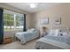 Comfortable bedroom with twin beds and a large window, decorated with calming blue tones and natural light at 17727 Garsalaso Cir, Brooksville, FL 34604
