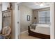 Inviting bedroom showcasing a doorway view, adorned with a decorative wood bench and a charming bed with a dark wood frame at 17727 Garsalaso Cir, Brooksville, FL 34604
