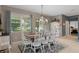 Comfortable dining room boasts natural light and backyard views, with seating for six under an elegant chandelier at 17727 Garsalaso Cir, Brooksville, FL 34604