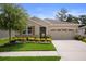Beautiful home with manicured lawn, colorful flower beds, and a spacious two-car garage at 17727 Garsalaso Cir, Brooksville, FL 34604