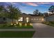Charming home with a two-car garage, beautiful landscaping, and an inviting, well-lit exterior at 17727 Garsalaso Cir, Brooksville, FL 34604