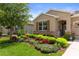 Close up of a house showing the front yard, colorful flowers, a window and part of the garage at 17727 Garsalaso Cir, Brooksville, FL 34604