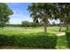 Picturesque golf course view with a pond, sand trap, and mature trees, offering a peaceful ambiance at 17727 Garsalaso Cir, Brooksville, FL 34604