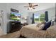 Main bedroom featuring a ceiling fan, dresser with TV, and natural light at 17727 Garsalaso Cir, Brooksville, FL 34604