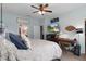 Main bedroom showcasing decor, ceiling fan, natural light, and a door to the main bathroom at 17727 Garsalaso Cir, Brooksville, FL 34604