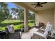 Inviting screened patio with cozy seating, offering a tranquil view of the lush green golf course and mature trees at 17727 Garsalaso Cir, Brooksville, FL 34604