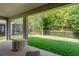 View from covered back patio overlooking a fenced backyard and greenery at 17843 Garsalaso Cir, Brooksville, FL 34604