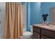 Bathroom featuring a shower with tan curtain and granite vanity at 17843 Garsalaso Cir, Brooksville, FL 34604