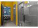 Clean bathroom boasting a glass-enclosed shower with built-in seating, complemented by vibrant yellow walls at 17843 Garsalaso Cir, Brooksville, FL 34604
