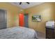 Bright bedroom with ceiling fan, TV, printer, and gray door at 17843 Garsalaso Cir, Brooksville, FL 34604
