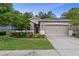 Charming single-Gathering home featuring a well-maintained lawn, mature trees, and neutral exterior paint at 17843 Garsalaso Cir, Brooksville, FL 34604