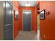 Vibrant hallway with orange walls, tiled floors, and a view of the front door at 17843 Garsalaso Cir, Brooksville, FL 34604