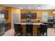 Stylish kitchen featuring granite island, dark cabinets, and modern appliances at 17843 Garsalaso Cir, Brooksville, FL 34604