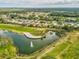 Aerial view of a pond and golf course surrounded by single-Gathering homes in a well-maintained community at 18845 Fairway Green Dr, Hudson, FL 34667