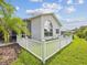Well-maintained backyard featuring a white picket fence, lush lawn, and screened patio area at 18845 Fairway Green Dr, Hudson, FL 34667
