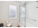 Clean and bright bathroom featuring a shower with glass doors, white tile, and a window at 18845 Fairway Green Dr, Hudson, FL 34667